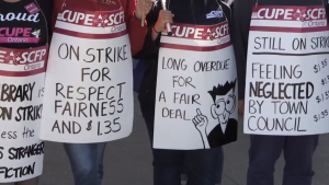 Striking library workers hold signs in Bradford West Gwillimbury, Ont. (CTV News)