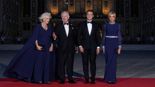 French President Emmanuel Macron, center right, his wife Brigitte Macron, right, King Charles III, centre left, and Queen Camilla arrive for a state dinner, at the Chateau de Versailles, west of Paris, Wednesday, Sept. 20, 2023. (AP Photo/Christophe Ena)
