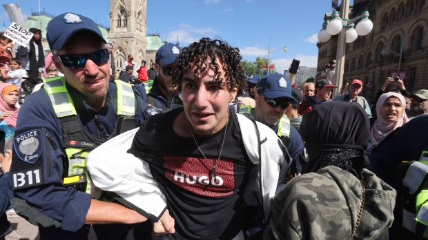 A protestor is arrested at a demonstration against sexual orientation and gender identity programs in schools, in front of Parliament Hill in Ottawa on Wednesday, Sept. 20, 2023. The protest was one of many across Canada, organized by "1MillionMarch4Children," as they protest against so-called "gender ideology" being taught in schools. (Patrick Doyle/THE CANADIAN PRESS)
