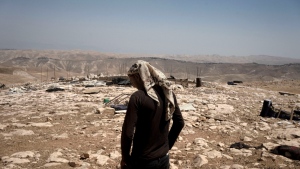 FILE - Palestinian shepherd Mustafa Arara, 24, stands in the ruins of the West Bank Bedouin village of al-Baqa where residents fled in July after settlers established an outpost a stone's throw from the village in June, Wednesday, Aug. 9, 2023. Over 1,100 Palestinians have fled their homes in the West Bank since the start of 2022, according to a report from the UN released Thursday, Sept. 21, 2023. Officials described the exodus as unprecedented in recent memory. They attribute the displacement to increasing levels of violence from Israeli settlers directed toward Palestinians in the territory. (AP Photo/Maya Alleruzzo, File)