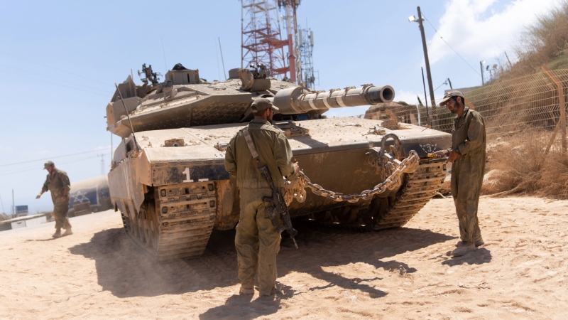 FILE- Israeli soldiers work on their tank in a position on the Israel-Lebanon border Thursday, Aug. 10, 2023. The Lebanese army said troops fired tear gas at Israeli soldiers in a disputed area along the tense border Saturday. No one was hurt in the incident. (AP Photo/Ohad Zwigenberg, File)
