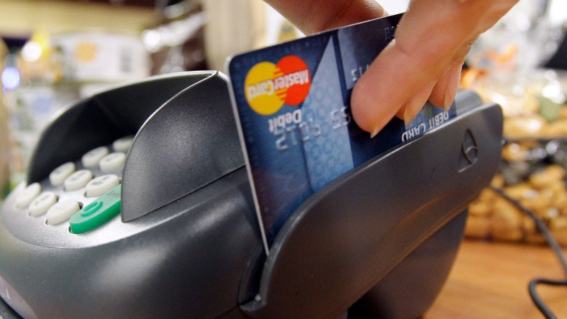 A customer swipes a MasterCard debit card through a machine while checking out at a shop in Seattle, Nov. 2, 2009. THE CANADIAN PRESS/AP-Elaine Thompson