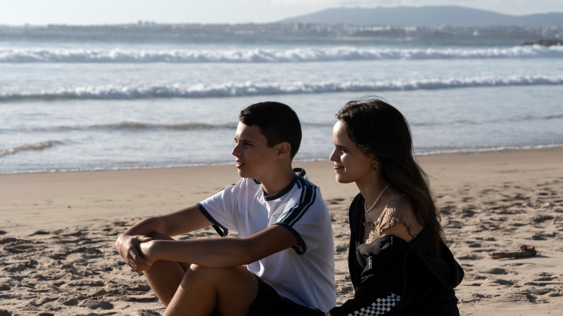 Siblings Sofia Oliveira, 18, and Andre Oliveira, 15, pose for a picture at the beach in Costa da Caparica, south of Lisbon, Wednesday, Sept. 20, 2023. (AP Photo/Ana Brigida)