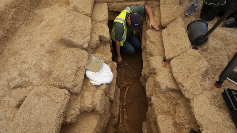 A Palestinian archeologist removes the sand from a skeleton in a grave at the Roman cemetery in Jebaliya northern Gaza Strip on Sept. 23, 2023. The ancient cemetery was uncovered last year during construction of a housing project. Researchers have uncovered 135 graves, including two sarcophagi made of lead. (AP Photo/Adel Hana)