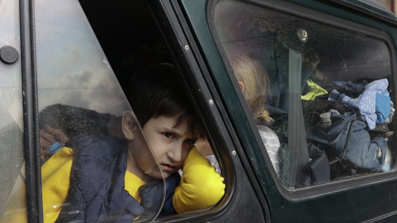 An ethnic Armenian boy from Nagorno-Karabakh, looks on from a car upon arrival in Armenia's Goris, the town in Syunik region, Armenia, Monday, Sept. 25, 2023. (AP Photo/Vasily Krestyaninov)