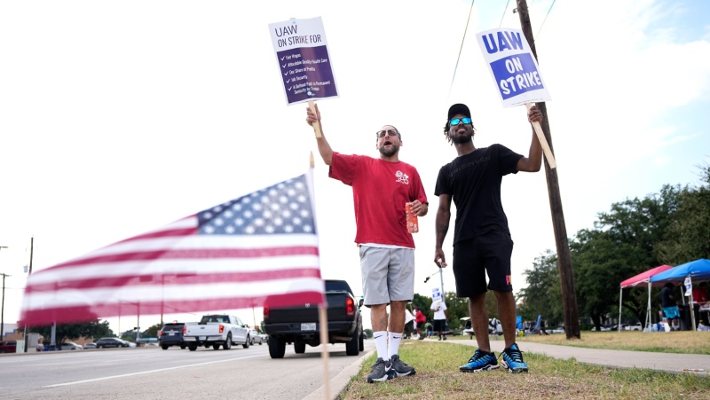 Philip Laws, left, and Robert Williams, join UAW union members as they picket on the street in front of a Stellantis distribution centre, Monday, Sept. 25, 2023, in Carrollton, Texas. (AP Photo/Tony Gutierrez)