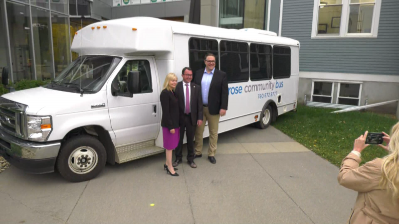 From left to right, MLA Jackie Lovely, Camrose Mayor PJ Stasko, and Seniors, Community and Social Services Minister Jason Nixon pose for a photo in front of a Camrose bus on Sept. 26, 2023, at the University of Alberta Augustana Campus. (CTV News Edmonton / Matt Marshall) 