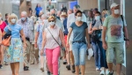 People wear face masks as they walk through a subway station in Montreal, Sunday, July 17, 2022. THE CANADIAN PRESS/Graham Hughes