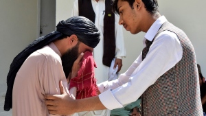 A man comforts another mourning for his relative, who was killed in the bomb explosion, at a hospital, in Quetta, Pakistan, Friday, Sept. 29, 2023. (AP Photo/Arshad Butt)