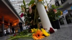 Medical personnel of the Erasmus Medical Centre pass flowers left to commemorate victims of a shooting in Rotterdam, Netherlands, Friday, Sept. 29, 2023. (AP Photo/Peter Dejong)
