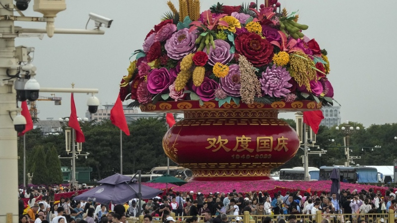 Visitors gather near a giant flower basket on display at the crowded Tiananmen Square to celebrate the 74th anniversary of the founding of the People's Republic of China, in Beijing on Thursday, Sept. 28, 2023. (AP Photo/Andy Wong)