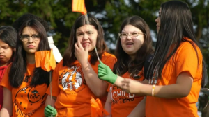 Students wearing orange shirts are pictured with orange flags on Sept. 28, 2023. More than 500 students from four schools joined the Sipekne’katik community to place orange flags in the shape of a heart on the site of the former Shubenacadie Residential School. 