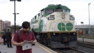A commuter reads a newspaper as a GO train arrives at the Oakville, Ont. GO Station, Tuesday, June 30, 2009. (Richard Buchan/THE CANADIAN PRESS)