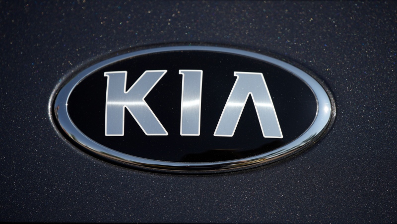 FILE - The company logo shines off the hood of a 2021 K5 sedan on display in the Kia exhibit at the Denver auto show Friday, Sept. 17, 2021 (AP Photo/David Zalubowski, File)