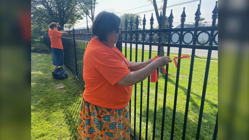 UPEI Elder in Residence, Judy Clark, tying orange ribbons at a ceremony for Truth and Reconciliation on Friday. (CTV/Jack Morse)