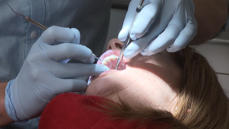 A dentist works on a patient's teeth in this file photo.