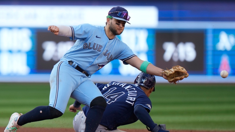 Tampa Bay Rays catcher Christian Bethancourt (14) is safe at third base after Toronto Blue Jays shortstop Bo Bichette (11) can't get to the throw during sixth inning American League MLB baseball action in Toronto, Saturday, Sept. 30, 2023. THE CANADIAN PRESS/Frank Gunn