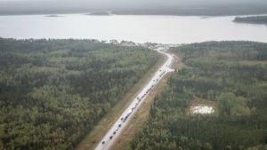 Vehicles line up for fuel at Fort Providence, N.W.T., on the only road south from Yellowknife, Aug. 17, 2023. THE CANADIAN PRESS/Jeff McIntosh