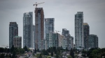 An Air Canada Boeing 787 aircraft arriving from Toronto passes behind condo towers in the Metrotown area of Burnaby, B.C., while on approach to land at Vancouver International Airport, on Sunday, May 30, 2021. THE CANADIAN PRESS/Darryl Dyck