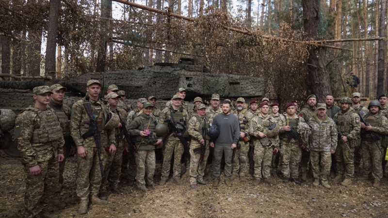 In this photo provided by the Ukrainian Presidential Press Office, Ukrainian President Volodymyr Zelenskyy, center, poses for photo with the Ukrainian soldiers in front of a Leopard 2 tank on the front line in the Kharkiv region, Ukraine, Tuesday, Oct. 3, 2023. (Ukrainian Presidential Press Office via AP)
