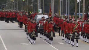 A  procession for RCMP Const. Rick O'Brien marches toward the Langley Events Centre for a regimental funeral service, on Oct. 4, 2023.