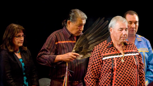 Justice Murray Sinclair, Chair of the Residential Schools Truth and Reconciliation Commission (TRC), is smoked in as Commissioner Marie Wilson, left, and Commissioner Chief Wilton Littlechild, right, look on as they take part in a ceremony in Gatineau, Quebec on July 16, 2009. (Sean Kilpatrick / THE CANADIAN PRESS)