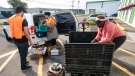 A group loads food to be taken to agencies to distribute to those in need at the Edmonton Food Bank, in Edmonton on Friday, July 21, 2023. (THE CANADIAN PRESS/Jason Franson.)