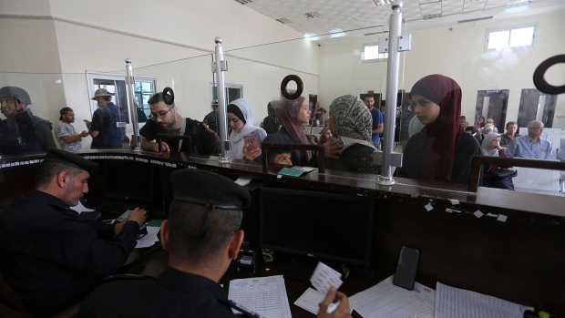 Palestinians with dual nationality register to cross to Egypt on the Gaza Strip side of the border crossing in Rafah on Thursday, Nov. 2, 2023. (AP Photo/Hatem Ali)