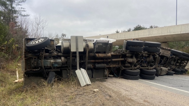 A transport truck rolled onto its side spilling a load of lumber onto Highway 11 in Gravenhurst, Ont., on Tues., Nov. 7, 2023. (Courtesy: Currie Heavy Towing)
