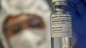 In this Thursday Oct. 15, 2020 file photo, a bottle containing the drug Remdesivir is held by a health worker at the Institute of Infectology of Kenezy Gyula Teaching Hospital of the University of Debrecen in Debrecen, Hungary. (Zsolt Czegledi/MTI via AP, File)
