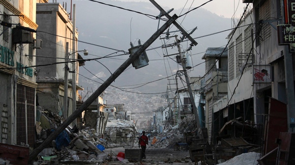 In this photo taken Tuesday, Feb. 16, 2010, a man walks down an earthquake damaged street with fallen electrical lines in Port-au-Prince.(AP/Dario Lopez-Mills)