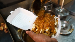 A cook prepares a poutine at La Banquise restaurant in Montreal on Tuesday, May 18, 2021. The restaurant has been sold to Chez Ashton owners. THE CANADIAN PRESS/Paul Chiasson