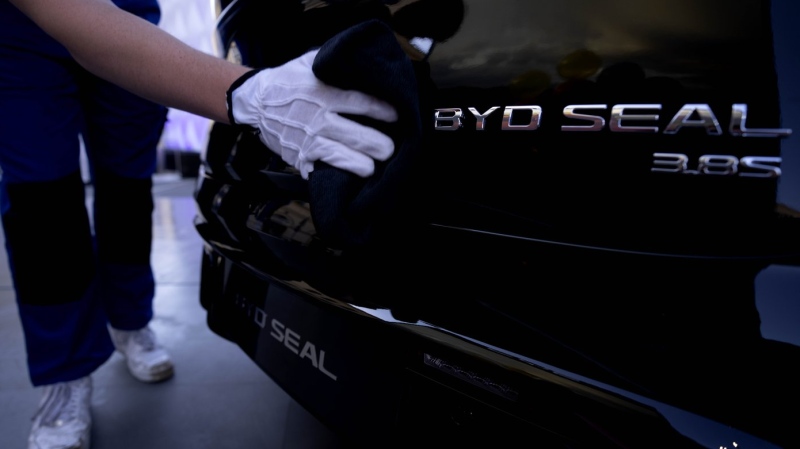 An employee cleans a BYD Seal car at the IAA motor show in Munich, Germany, Sept. 8, 2023. (AP Photo/Matthias Schrader, File)