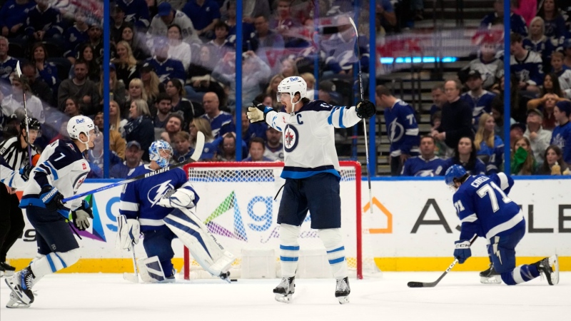 Winnipeg Jets center Adam Lowry (17, center) celebrates after scoring the game-winning goal against the Tampa Bay Lightning during the third period of an NHL hockey game Wednesday, Nov. 22, 2023, in Tampa, Fla. (AP Photo/Chris O'Meara)