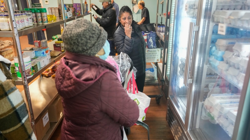 Betsy Quiroa, centre, shops at a market-style food pantry at the Carver Center in Port Chester, N.Y., Wednesday, Nov. 15, 2023. A growing number of states are working to keep food out of landfills over concerns that it is taking up too much space and posing environmental problems. Some states including New York are requiring supermarkets and other businesses to redirect food to food pantries. (AP Photo/Seth Wenig)