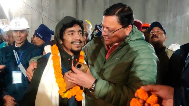 This handout photo provided by the Uttarakhand State Department of Information and Public Relations shows Pushkar Singh Dhami, right, Chief Minister of the state of Uttarakhand, greeting a worker rescued from the site of an under-construction road tunnel that collapsed in India, Tuesday, Nov. 28, 2023. (Uttarakhand State Department of Information and Public Relations via AP)