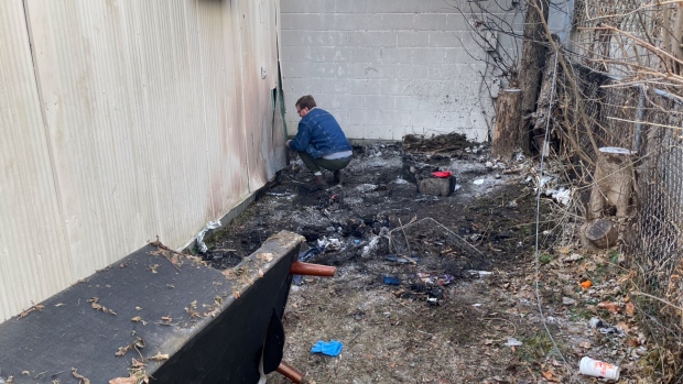 Michael Pasch repairs a damaged wall following a fire behind his business in London, Ont. on Nov 28, 2023. The accidental fire, inside a tent occupied by a woman experiencing homelessness the night before, left her with serious burns. (Sean Irvine/CTV News London) 
