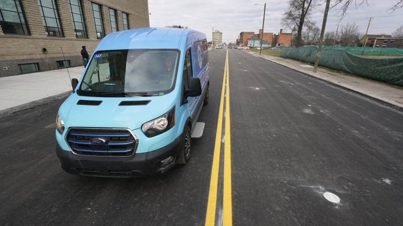 An electric van drives on a street with in-road wireless charging coils below the surface in Detroit, Wednesday, Nov. 29, 2023. A demonstration of the first electric vehicle charging road in the U.S. took place Wednesday on a quarter-mile stretch of a Motor City street. (AP Photo/Paul Sancya)