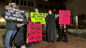 A small group of protesters stand outside Region of Waterloo headquarters on Nov. 29, 2023 ahead of a public input session on next year's budget. (Heather Senoran/CTV Kitchener)