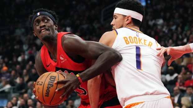 Toronto Raptors' Pascal Siakam (43) tries to get around Phoenix Suns' Devin Booker (1) during first half NBA basketball action in Toronto on Wednesday, November 29, 2023. THE CANADIAN PRESS/Chris Young