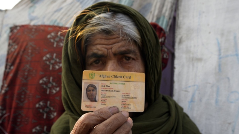 An Afghan refugee show her identity card during a search operation against illegal immigrants at a neighbourhood of Karachi, Pakistan, Tuesday, Nov. 21, 2023. (AP Photo/Fareed Khan)