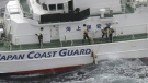 Japanese coast guard members pick up a floating object as they conduct search and rescue operation in the waters off Yakushima Island, Kagoshima prefecture, southern Japan Thursday, Nov. 30, 2023. Japan plans to suspend its own Osprey flights after a U.S. Air Force Osprey based in Japan crashed into waters off the southern coast during a training mission, officials said Thursday. (Kyodo News via AP)