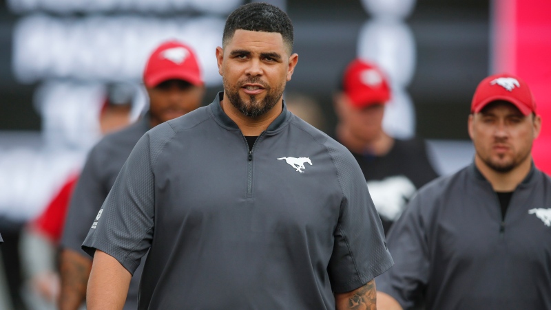 Calgary Stampeders defensive line coach Corey Mace takes to the field during CFL pre-season football action in Calgary, Friday, May 31, 2019. THE CANADIAN PRESS/Jeff McIntosh