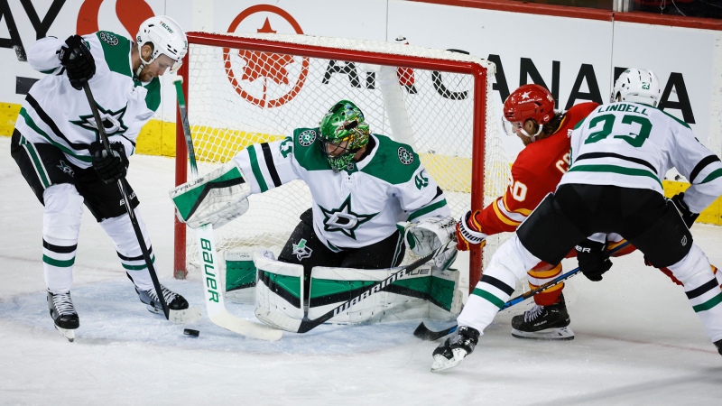 Dallas Stars goalie Scott Wedgewood, centre, looks on as teammate forward Radek Faksa, left, clears the puck as Calgary Flames forward Blake Coleman is checked by defenceman Esa Lindell during second period NHL hockey action in Calgary, Thursday, Nov. 30, 2023.THE CANADIAN PRESS/Jeff McIntosh