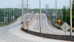 The approach to the Ile-aux-Tourtes bridge on Highway 40 is seen empty of traffic after being closed, in Montreal, Friday, May 21, 2021. The bridge is the major connection between Quebec and Ontario, carrying upwards of 80,000 vehicles a day on and off of the island. THE CANADIAN PRESS/Peter McCabe