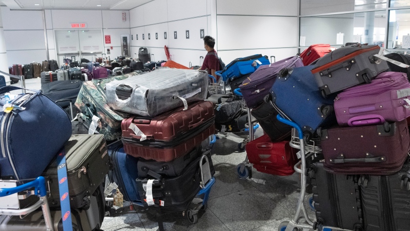 A passenger looks for his luggage among a pile of unclaimed baggage at Pierre Elliott Trudeau airport, in Montreal, Wednesday, June 29, 2022. (THE CANADIAN PRESS/Ryan Remiorz)