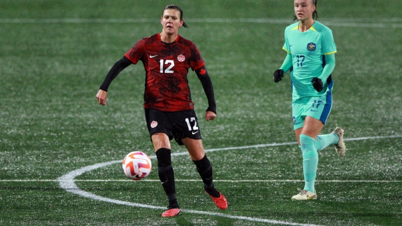 Christine Sinclair passes the ball as Australia's Amy Sayer looks on during second half soccer action at Starlight Stadium in Langford, B.C., on Friday, December 1, 2023. THE CANADIAN PRESS/Chad Hipolito