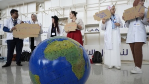 People participate in a demonstration to highlight the link between health and climate at the COP28 UN Climate Summit, Sunday, Dec. 3, 2023, in Dubai, United Arab Emirates. (AP Photo/Peter Dejong)