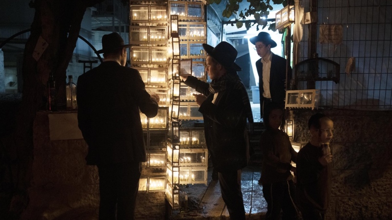 Ultra-Orthodox Jewish seminary students light candles on the fifth night of Hanukkah in the Mea Shearim neighbourhood of Jerusalem, Thursday, Dec. 22, 2022. (THE CANADIAN PRESS/AP-Maya Alleruzzo)