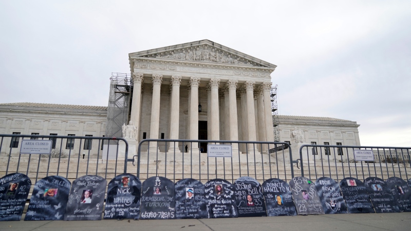 Signs in the shape of grave headstones, with information on people who died from using OxyContin, line a security fence outside the Supreme Court Monday, Dec. 4, 2023, in Washington.The Supreme Court is wrestling with a nationwide settlement with OxyContin maker Purdue Pharma that would shield members of the Sackler family who own the company from civil lawsuits over the toll of opioids. (AP Photo/Stephanie Scarbrough)